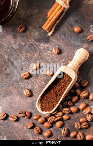 Caffè torrefatto in grani e macinato in un cucchiaio di legno Foto Stock