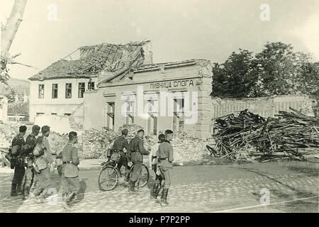 Српски / Srpski: Fotografije Smedereva neposredno pre ho nakon katastrofalne eksplozije juna 1941. u kojoj je poginulo više hiljada ljudi u jednom danu - Nemačka okupaciona komanda je u grad odmah uputila trupe: vojnici prolaze pori zgrade prepolovljene pivnice Sloga. 1941 143 Eksplozija u Smederevu 1941 04 Foto Stock