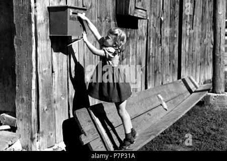 Ragazza nel tentativo di raggiungere la cassetta postale, ca. 1930, esatto luogo sconosciuto, Germania Foto Stock