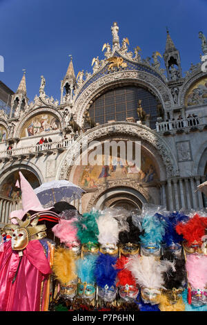 Maschera in stallo al di fuori della Basilica di San Marco, Piazza San Marco, Venezia: il contrasto tra il turista appiccicoso tat e il bellissimo mosaico sull'entrata Foto Stock