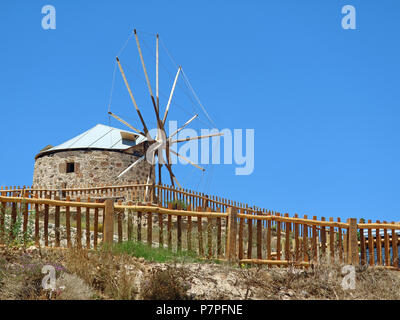 Tradizionale vecchio mulino a vento dietro la recinzione in legno in Grecia Foto Stock