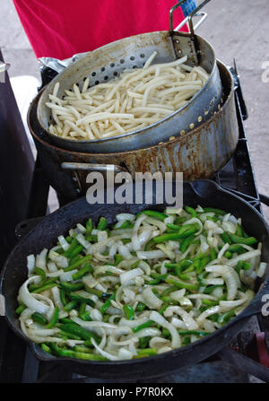 Mescolare friggere le cipolle e friggere le patatine fritte all'aperto Foto Stock