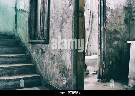 Bagno rotto vicino a una scala di cariati in condannato edificio. Foto Stock