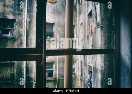 Da un metallico marcio sul telaio di una finestra di un edificio usurato la vista delle pareti incrinate, appartamento windows e tubi. San Paolo. Il Brasile. N. persone. Foto Stock