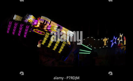 Arcobaleno colorato, filatura corse di Midway a Calgary Stampede, si trova nella città di Calgary, Alberta, Canada. La sfocatura in movimento ha creato un aspetto astratto. Foto Stock