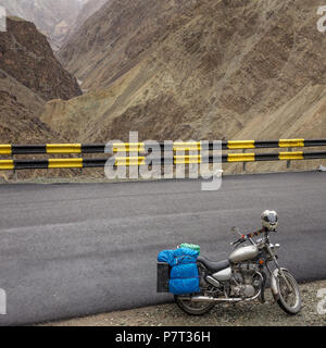 Il motociclismo Leh Manali autostrada, una alta altitudine strada che attraversa la grande gamma Himalayana, Ladakh, India. Moto parcheggiata con i bagagli su th Foto Stock