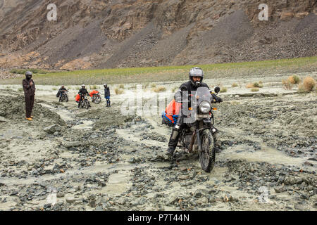 Valle di Nubra, India - 30 Giugno 2017: Unidentified biker attraversando parte della strada coperta di fango dopo la frana in Himalaya, Ladakh regio Foto Stock