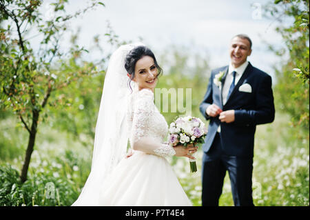 Nozze da favola giovane aventi il loro tempo all'aperto nel giardino in un giorno speciale. Foto Stock