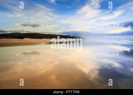 Sky riflessa nell'acqua della sabbia bagnata sulla spiaggia, sull'oceano acqua di mare, spiaggia sabbiosa di Tarifa, Andalusia, Spagna Foto Stock