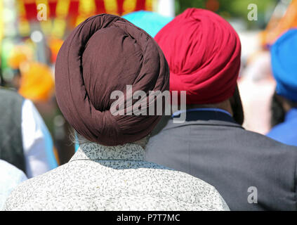 A piedi nudi uomini Sikh con turbanti durante una cerimonia religiosa Foto Stock