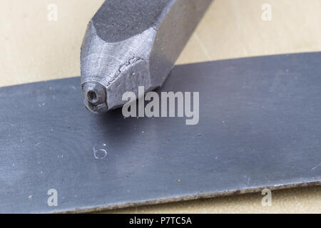 I timbri di metallo per la stampigliatura di numeri e lettere in metallo. Le cifre in rilievo in metallo. Un officina di fabbro. Foto Stock