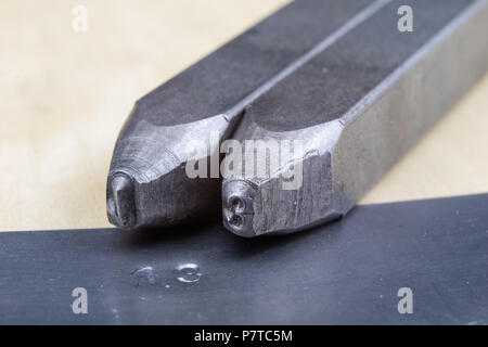 I timbri di metallo per la stampigliatura di numeri e lettere in metallo. Le cifre in rilievo in metallo. Un officina di fabbro. Foto Stock