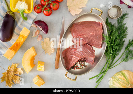 Pezzo grezzo di filetto di manzo con verdure sulla superficie luminosa, vista dall'alto Foto Stock