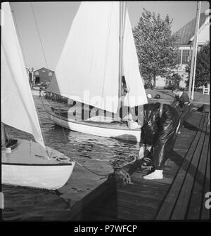 Finnland, Helsinki: Segeln; Ein Mann und eine Frau befestigen Segelboote. Giugno 1937 70 CH-NB - Finnland, Helsinki- Segeln - Annemarie Schwarzenbach - SLA-Schwarzenbach-UN-5-17-030 Foto Stock