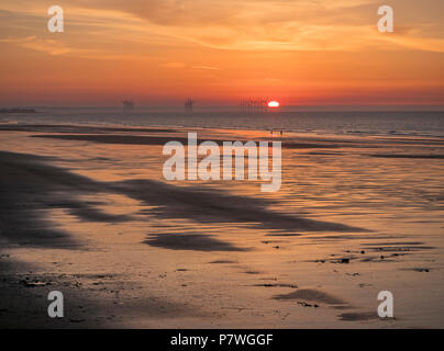 Impostazione del sole all'orizzonte e il Mare del Nord a Saltburn beach Foto Stock