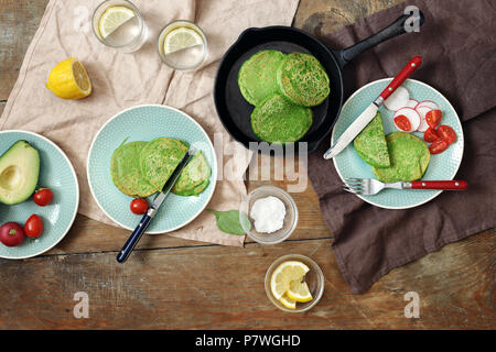 Vista dall'alto senza glutine frittelle di spinaci su un tavolo di legno. Colazione salutare concetto tavolo Foto Stock