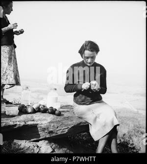 Stati Uniti d'America, Monteagle/TN: Highlander Folk School; Eine Frau sitzt auf einem Felsen und schält einen Apfel. Dal 1936 fino al 1938 86 CH-NB - USA, Monteagle-TN- Highlander Folk School - Annemarie Schwarzenbach - SLA-Schwarzenbach-UN-5-10C-122 Foto Stock