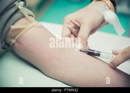 Close up per la raccolta di sangue al braccio. Le persone e il concetto di assistenza sanitaria. Ospedale e clinica del tema. Foto Stock