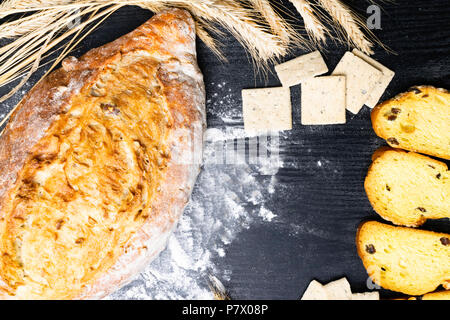 Pane integrale da tutto il frumento, segala e semi di lino, farina di frumento e di frumento integrale biscotti con uva passa e la curcuma, olive Foto Stock