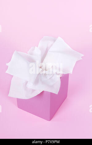 Fazzoletti di carta nella casella vuota su un morbido sfondo rosa. Foto Stock