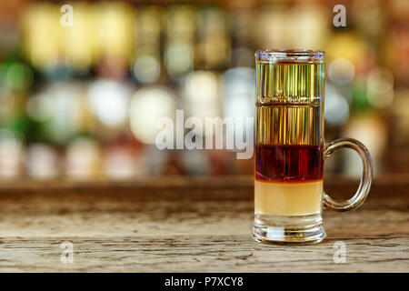 Un multi-layered cocktail di tre strati di alcool sulla barra in una discoteca. cocktail thujone timbro? Spazio per il testo Foto Stock