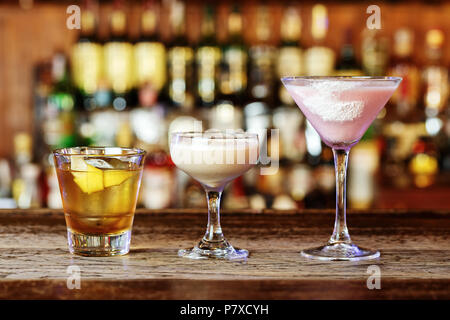 Diversi cocktail sul bar, cocktail di diverse bevande alcoliche in bicchieri di diverse forme, spazio per il testo Foto Stock