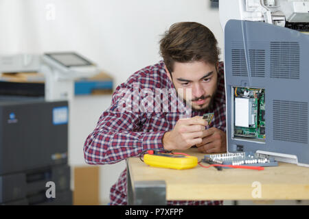 Uomo che fissa a getto di inchiostro del sistema di alimentazione Foto Stock