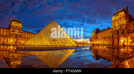 Parigi, Francia - luglio 1, 2017: panorama della Cour Napoleone del museo del Louvre a blue ora. La piramide di vetro e il Pavillon Rishelieu mirroring in un pool al crepuscolo. Palazzo del Louvre è un famoso punto di riferimento di Parigi Foto Stock