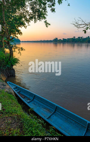 Fotografia verticale di un turchese canoa al tramonto lungo il fiume Napo all'interno del Yasuni National Park, Ecuador. Foto Stock