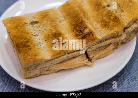 Tradizionale colazione Singapore chiamato Kaya toast, pane di cocco con marmellata e burro, il fuoco selettivo tecnica Foto Stock