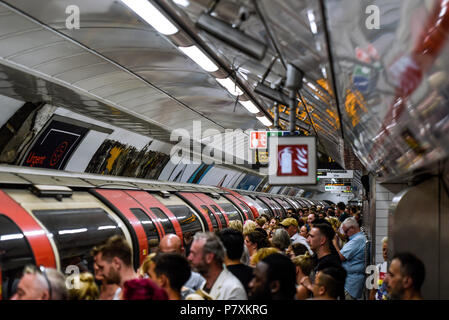 Affollata stazione della metropolitana di Londra e la piattaforma del treno, stazione di Tottenham Court Road occupato con i passeggeri nei periodi di picco. Pranzo Foto Stock