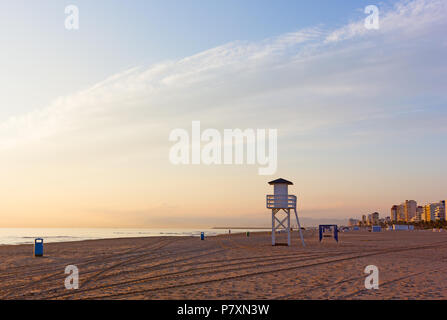 Mare di sabbia spiaggia presso sunrise a Gandia, regione di Valencia, Spagna. Nuvoloso sunrise in sfumature di colore arancione sopra il mare calmo. Foto Stock