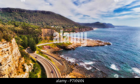 Si piega sulla costiera elevata Grand Pacific Highway drive costruito come una scogliera sul mare ponte lungo la costa del Pacifico in Australia su una soleggiata giornata estiva visto fro Foto Stock