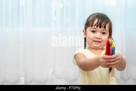 Carino bambina mettere colori pastello in aula. Si torna a scuola e istruzione concetto. Artista e pittura tema di classe. Foto Stock