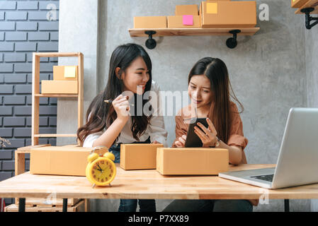 Due giovani donne asiatiche startup piccoli imprenditori PMI magazzino di distribuzione di pacchi con la casella di posta elettronica. piccoli proprietari home office. Online marketing Foto Stock