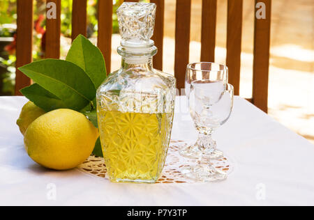 Lemoncello e limoni su un estate Impostazione tabella Foto Stock
