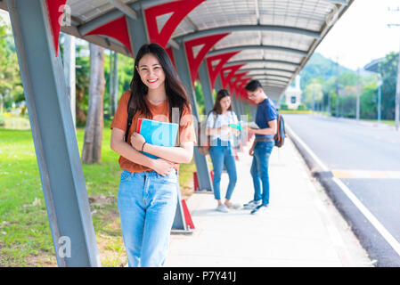 College giovani studenti asiatici il tutoraggio e la lettura di libro al marciapiede in università. Scuola e amicizia tema. Istruzione e concetto di graduazione. ragazza un Foto Stock