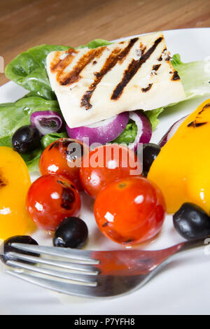 Un pranzo leggero di insalata tiepida di fritto il formaggio halloumi, peperoni, pomodori ciliegini e lattuga Foto Stock