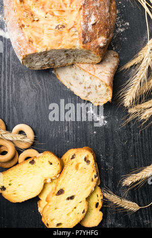 Pane integrale da tutto il frumento, segala e semi di lino, farina di frumento e di frumento integrale biscotti con uva passa e la curcuma, olive, bagel Foto Stock