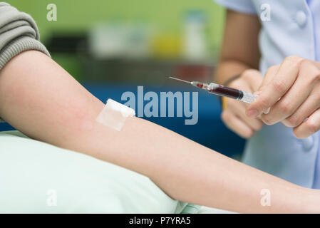 Raccogliere il sangue da un infermiere in ospedale, sangue di prova di esame e donare il concetto. Ospedale e health care concept Foto Stock