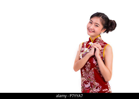 Giovani asiatici bellezza donna che indossa cheongsam e benedizione o gesto di saluto nel nuovo anno cinese festival evento isolato su sfondo bianco. Una vacanza Foto Stock