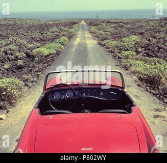 AUSTIN HEALEY SPRITE MK III DESCAPOTABLE ROJO AÑOS 60 EN ONU CAMINO RECTO ENTRE LA LAVA. Posizione: esterno, Isla, TENERIFFA, Spagna. Foto Stock