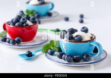 Gelato alla vaniglia con mirtilli freschi in tazze di ceramica, dessert estivo Foto Stock