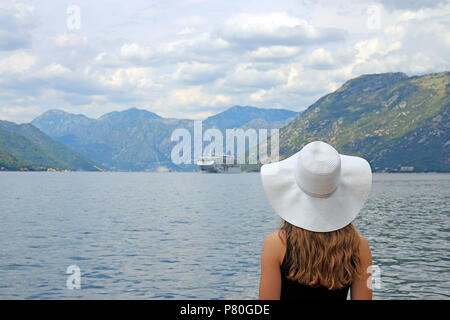 La ragazza guarda la nave da crociera di entrare nella Baia di Kotor Montenegro Foto Stock