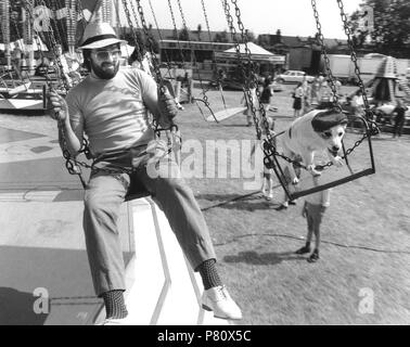 Uomo e Jack Russell Terrier alla guida di una giostra, Inghilterra, Gran Bretagna Foto Stock