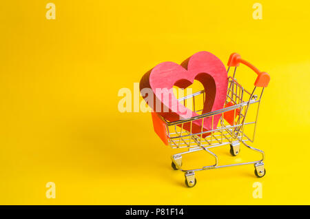 Un carrello per supermercati con un cuore rosso all'interno. Amore di shopping e negozi. Store preferito o al supermercato. Acquista amore e felicità. Gli appassionati di shopping, cons Foto Stock