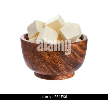 Greco cubetti di feta in ciotola di legno. Tagliate a dadini il formaggio morbido isolati su sfondo bianco Foto Stock
