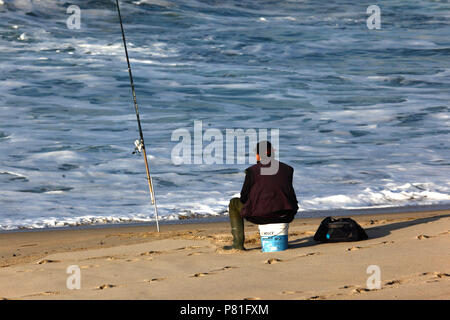 L'uomo della pesca in mare dal calderone Dune spiaggia / Praia da Duna do Caldeirao, vicino a Vila Praia de ancora, Provincia del Minho, Portogallo settentrionale Foto Stock