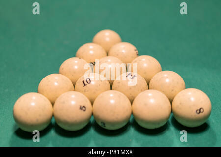 White palle da biliardo per Russo biliardo, in un triangolo sul tavolo. Russo palle da biliardo e cue sul tavolo, la piramide. Foto Stock