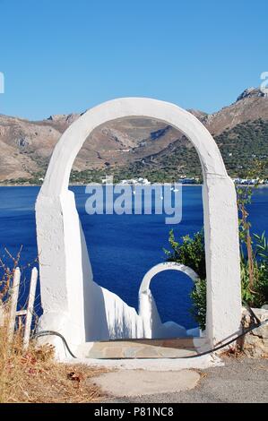 Un bianco archway telai porto di Livadia sull'isola greca di Tilos il 12 giugno 2018. Foto Stock